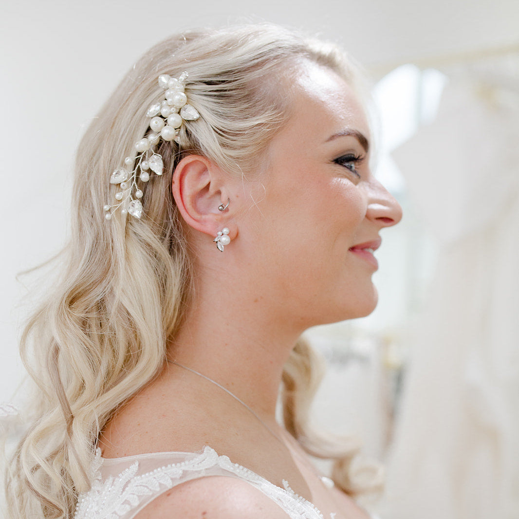 Pearl and crystal bridal hair comb nestled into soft blonde waves, featuring clustered ivory pearls and clear bead detailing for an elegant, organic finish.