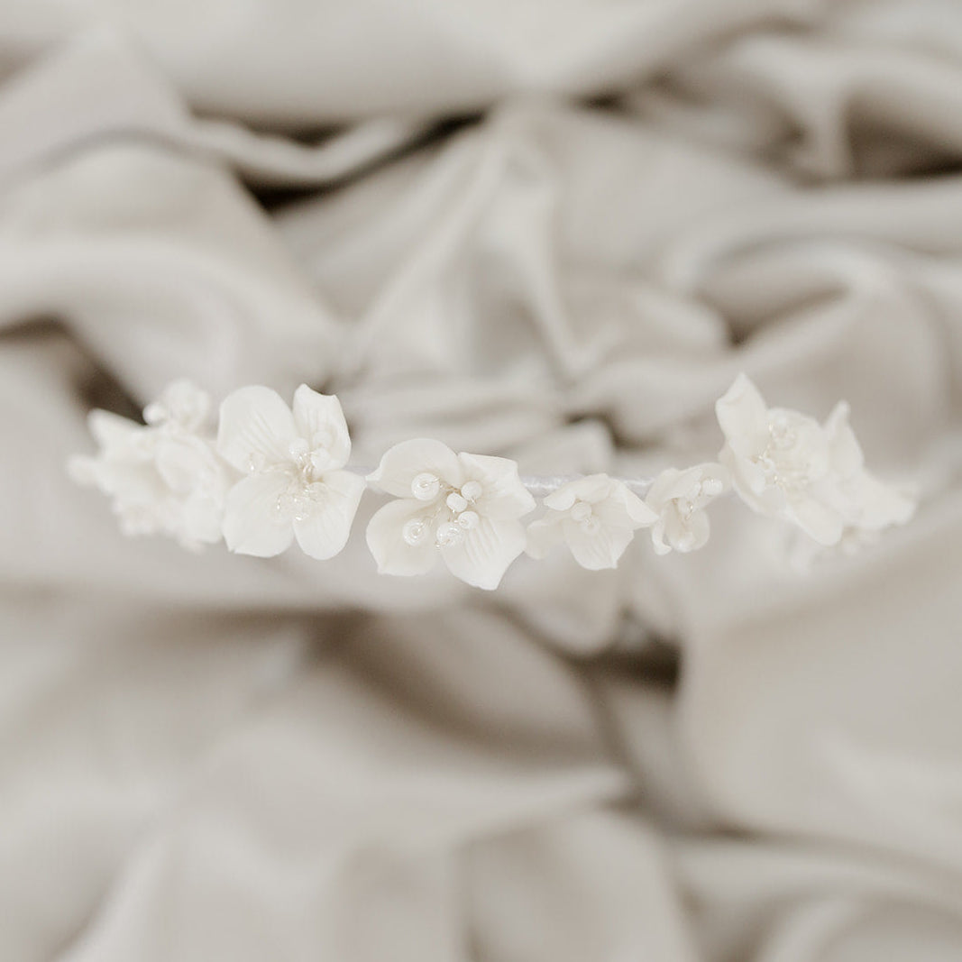Floral hair accessory on a textured beige fabric background