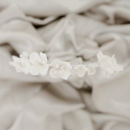 Floral hair accessory on a textured beige fabric background